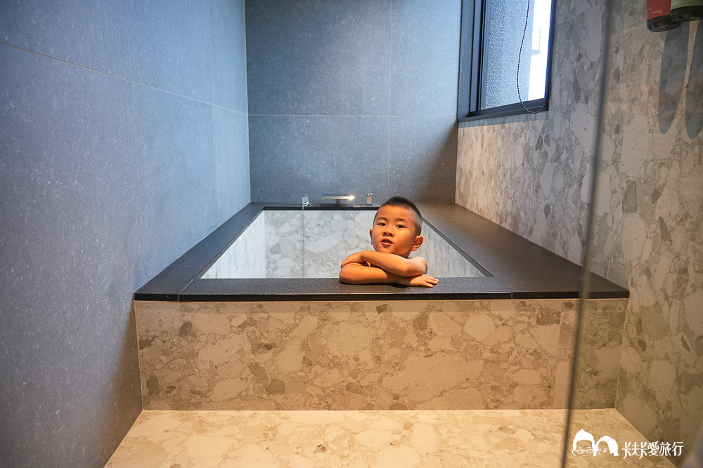 孩子趴在大浴缸邊沿，等著泡澡