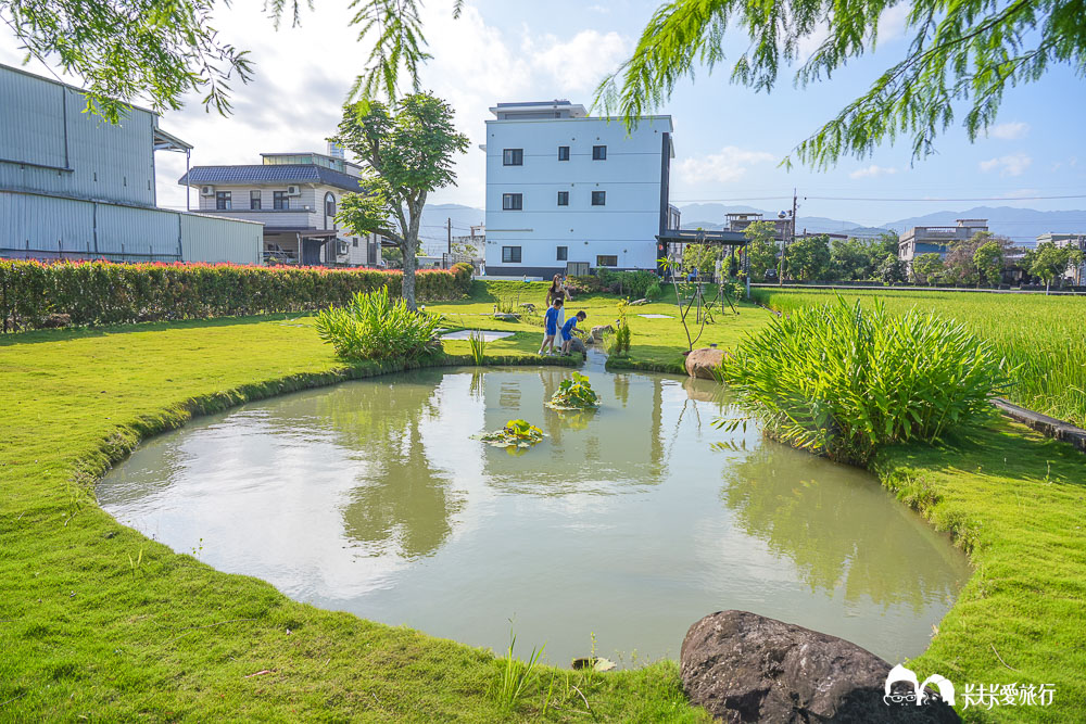 竹間民宿橢圓魚池，荷花與稻田背景